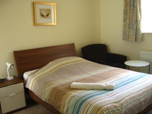 a bedroom with a bed with a towel on it at Simpson's Apartments in Daventry
