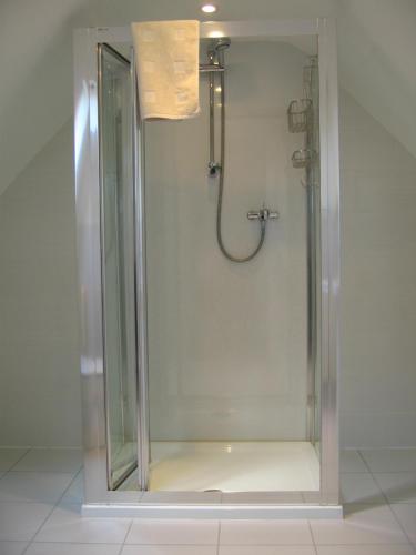 a shower with a glass door in a bathroom at Simpson's Apartments in Daventry