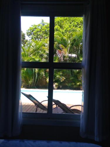 a window looking out at a view of a beach at Morada do Sol Guest House in Búzios