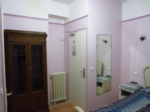 Cette chambre comprend un lit et deux miroirs sur le mur. dans l'établissement Hotel d'Orléans Paris Gare de l'Est, à Paris