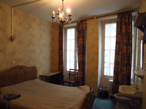 a bedroom with a bed and a sink and windows at Hotel d'Orléans Paris Gare de l'Est in Paris