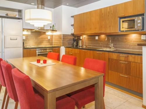 une cuisine avec une table en bois et des chaises rouges dans l'établissement Holiday Home Tahko spa suites orange a 8 by Interhome, à Tahkovuori