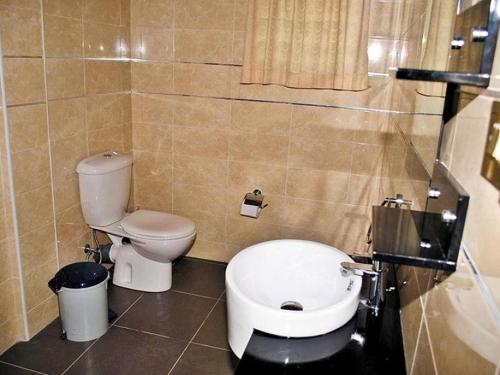 a bathroom with a toilet and a sink at Eusbett Hotel in Sunyani