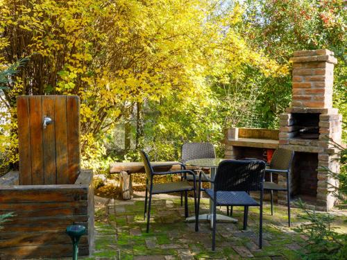 un patio con mesa, sillas y chimenea en Holiday Home Kiwi by Interhome, en Balatonfenyves