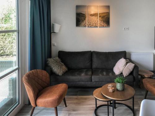 ein Wohnzimmer mit einem Sofa und einem Tisch in der Unterkunft Holiday Home Camping Cassandria Bad-1 by Interhome in Retranchement