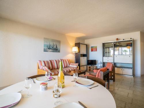 - un salon avec une table et des verres à vin dans l'établissement Apartment Ulysse Port de Plage by Interhome, au Grau-du-Roi