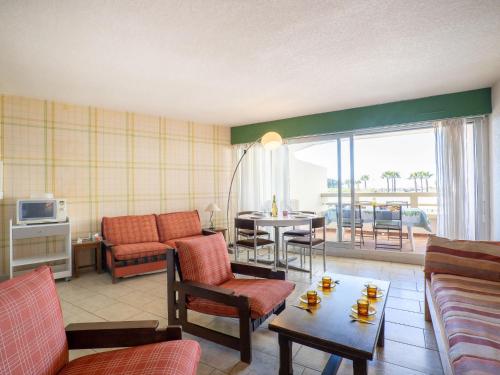 un salon avec un canapé et une table avec des chaises dans l'établissement Apartment Ulysse Port de Plage by Interhome, au Grau-du-Roi