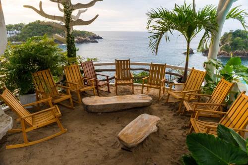a group of chairs and a bench on the beach at Hotel Pasión de Luna in Puerto Ángel
