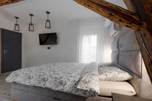 a bedroom with a bed and a tv on a wall at Apartman DOWNTOWN DL in Zagreb
