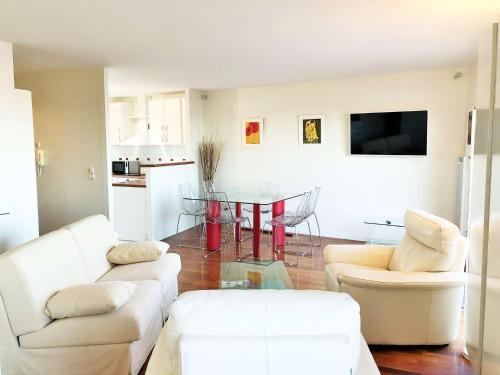 - un salon avec deux canapés blancs et une table dans l'établissement LUCIA appartement standing vue bassin, à Arcachon