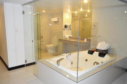 a bathroom with a tub and a shower and a sink at Sun Hotel in Santa Cruz de la Sierra