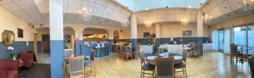 a room with tables and chairs in a building at Mitt hotell & apartments in Moss