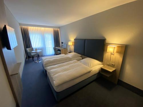 クルムバッハにあるフレア ホテル ドブラフタールのベッドとデスクが備わるホテルルームです。