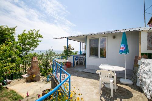een klein huis met een patio en een tafel bij Ваканционни къщи'На брега' Holiday houses ON THE COAST in Varna