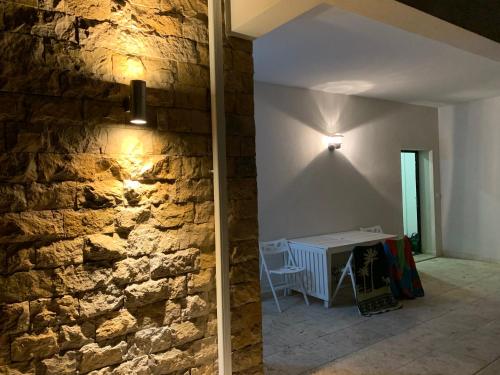 a room with a stone wall next to a table at Cecile's Villa in Casal do Pardo