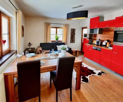 a kitchen with a wooden table and red cabinets at Kitzbühel Apartments Haus Brugger in Kitzbühel