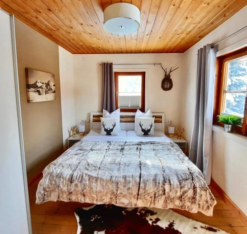 a bedroom with a large bed with a wooden ceiling at Kitzbühel Apartments Haus Brugger in Kitzbühel