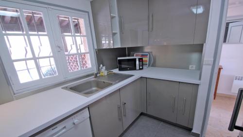 une cuisine avec un évier et un micro-ondes dans l'établissement El Cantarello, à Sainte-Maxime