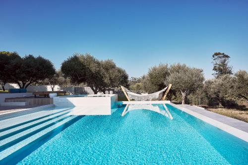una piscina con amaca e alberi sullo sfondo di Villa Carpos a Chania