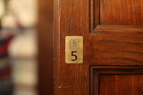 a wooden door with the number on it at Locanda Dell' Orso Bevitore in Verduno