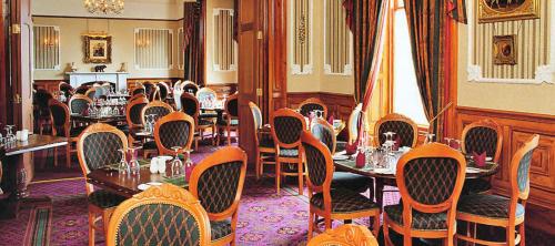 a restaurant with tables and chairs in a room at The Grand Hotel in Lerwick