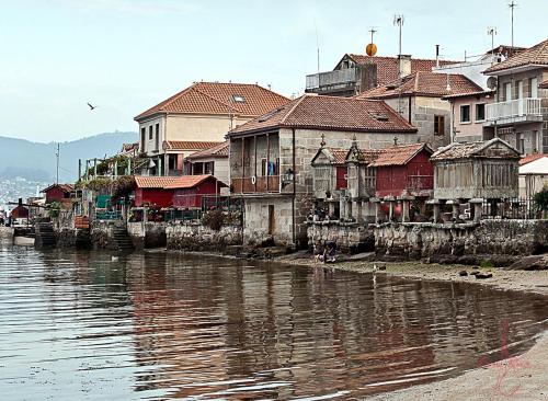 a group of houses next to a body of water at Hostal Xaraiba in Sanxenxo
