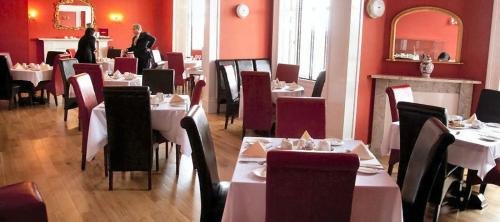 a restaurant with tables, chairs, and tables in it at The Grand Hotel in Lerwick