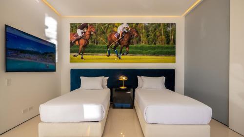 two beds in a room with a painting on the wall at PIER 57 - 508 Modern 2BR Condo Romantic Zone in Puerto Vallarta