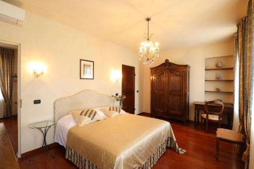 a bedroom with a bed and a chandelier at Locanda Dell' Orso Bevitore in Verduno