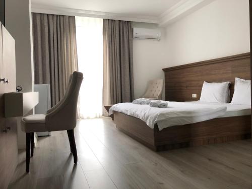 a bedroom with a bed and a desk and a chair at Hotel Dardani in Mitrovicë