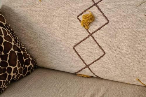 a close up of a pillow with a giraffe on it at Le Lodge, T2 classé 3 étoiles avec jardin, parking, piscine & mer à 2 pas in Menton