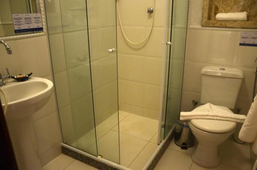 a shower in a bathroom with a toilet and a sink at Ilha Branca Exclusive Hotel in Búzios
