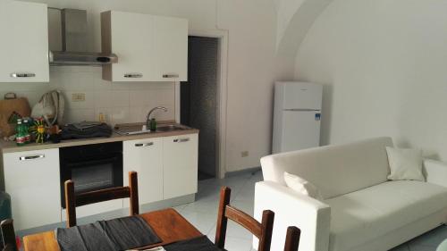 イスキアにあるLa Vecchia Locandaのリビングルーム(白いソファ付)、キッチンが備わります。