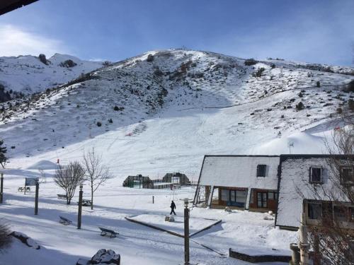 a building in the snow with a snow covered mountain at 2 Appt 4 à 6 pers Val Louron au pied des pistes in Génos