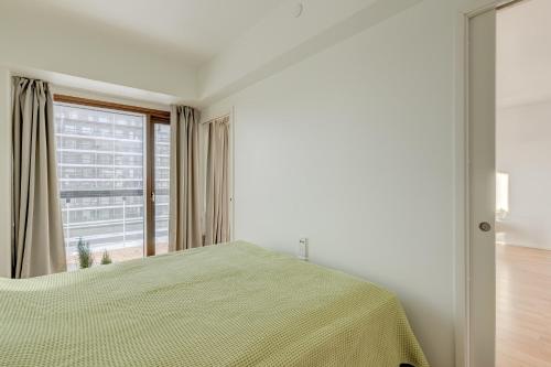 una camera da letto con un letto e una grande finestra di Tapiola Oak Apartment a Espoo