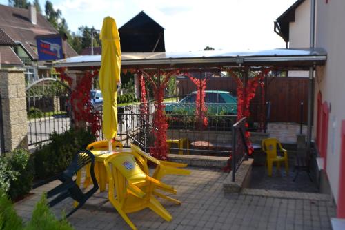 a playground with yellow chairs and a yellow umbrella at Penzion Abahouse in Liptovský Mikuláš