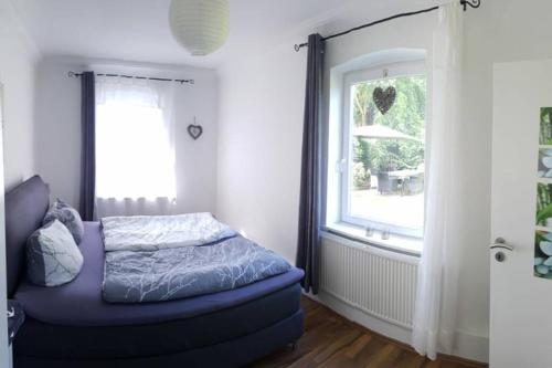 Schlafzimmer mit einem Bett und einem Fenster in der Unterkunft Gemütliche Haushälfte mit Garten und Terrasse in Flensburg