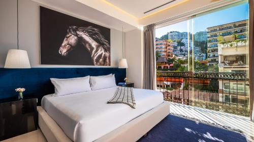 a bedroom with a bed and a window with a horse on the wall at PIER 57 - 508 Modern 2BR Condo Romantic Zone in Puerto Vallarta