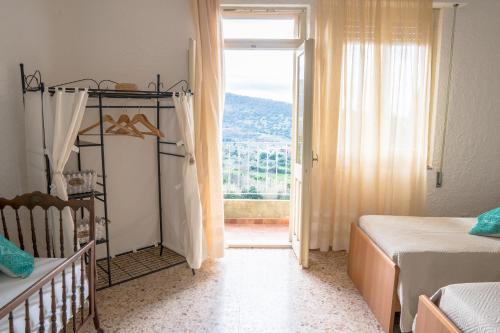 a bedroom with a crib and a window with a view at Da Fe' - Casa con terrazza panoramica in Cuglieri