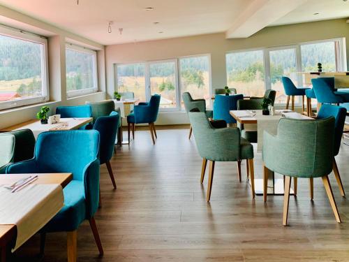 een restaurant met blauwe stoelen en tafels en ramen bij ArdoSpa Hotel and Restaurant in Sarnitsa
