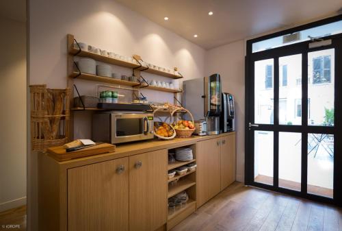 eine Küche mit einer Theke mit einer Mikrowelle und einem Fenster in der Unterkunft Hotel Mirabeau Eiffel in Paris