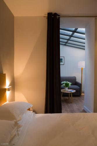 une chambre avec un lit et un canapé dans l'établissement Hotel Mirabeau Eiffel, à Paris