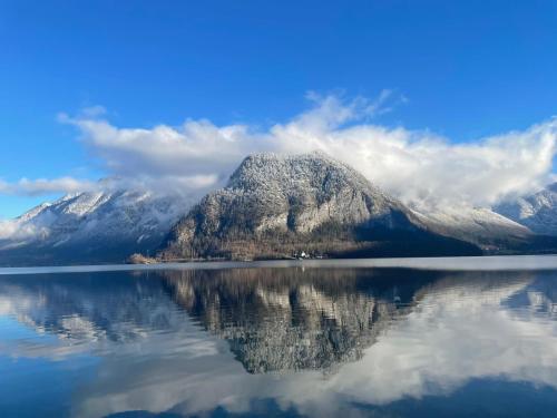 a mountain with its reflection in the water at Appartement Emilia in Hallstatt
