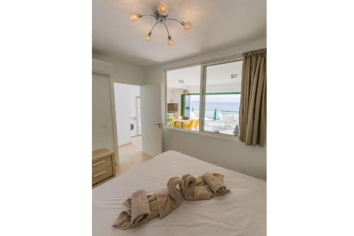 Un dormitorio con una cama con toallas. en SEA BREEZE Ocean View Apartment, en Playa Blanca