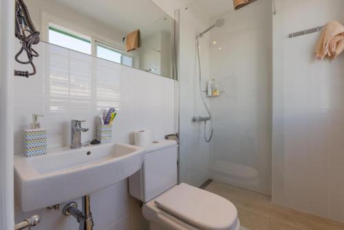 Un baño con lavabo, inodoro y ducha. en SEA BREEZE Ocean View Apartment, en Playa Blanca