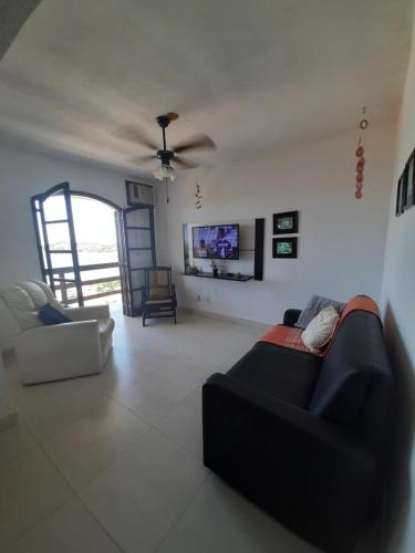 a living room with a couch and a tv at Vista Panorâmica em São Pedro da Aldeia in Rio de Janeiro