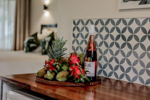 a bottle of beer and flowers on a counter at Tai Roto Bay in Arutanga