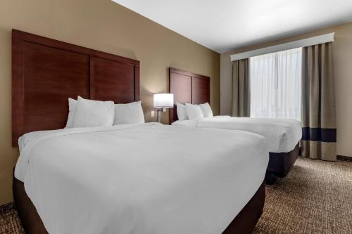 a hotel room with two beds and a window at Comfort Inn & Suites, White Settlement-Fort Worth West, TX in Fort Worth