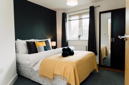 ein Schlafzimmer mit einem Bett mit einer schwarzen Wand in der Unterkunft Gated Parking I Kitchen I WIFI I Netflix I Spacious I PRIDE APARTMENTS in Derby