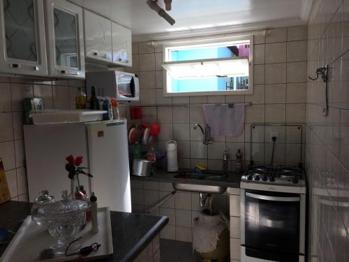 uma pequena cozinha com um frigorífico e um lavatório em Ape lindo em Porto - Oxente reserve logo em Porto Seguro